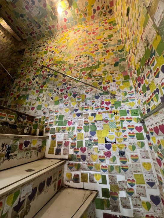 Escalera decorada con corazones de colores en las paredes.