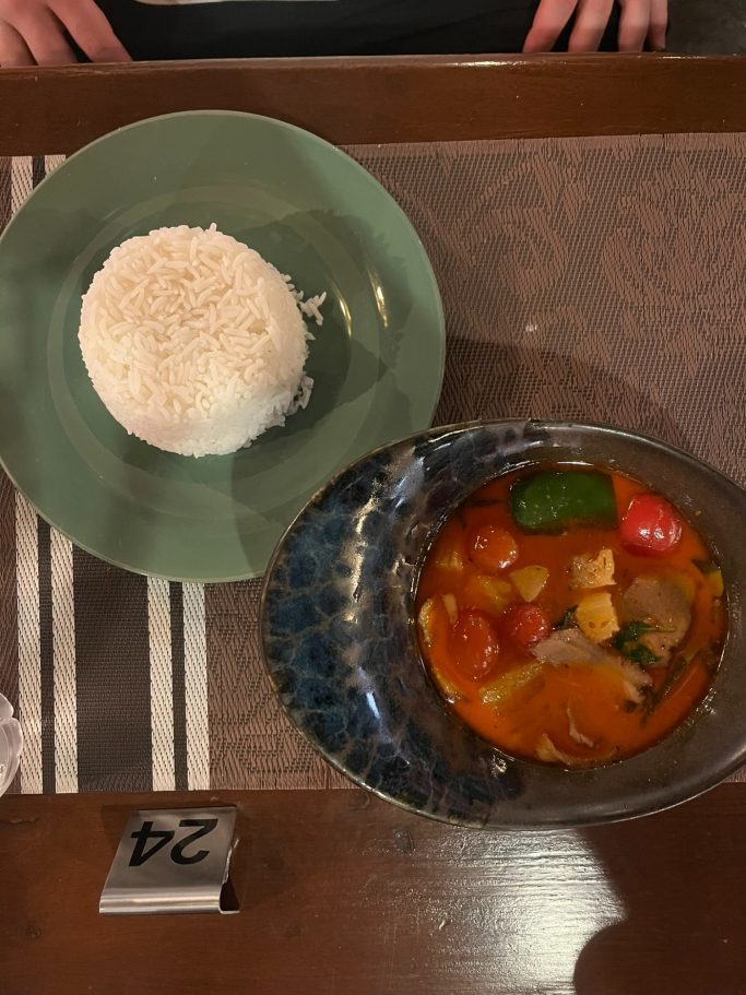 Plato de arroz blanco con guiso de verduras y carne en salsa, presentado en un plato hondo.