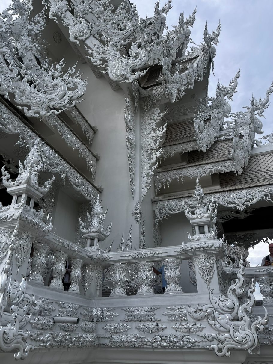 Templo blanco con elaborados detalles en yeso y arquitectura tradicional tailandesa.