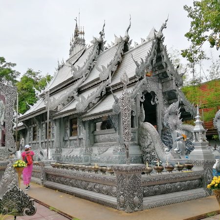 Templo decorado en plateado, rodeado de vegetación, con detalles elaborados en la arquitectura.