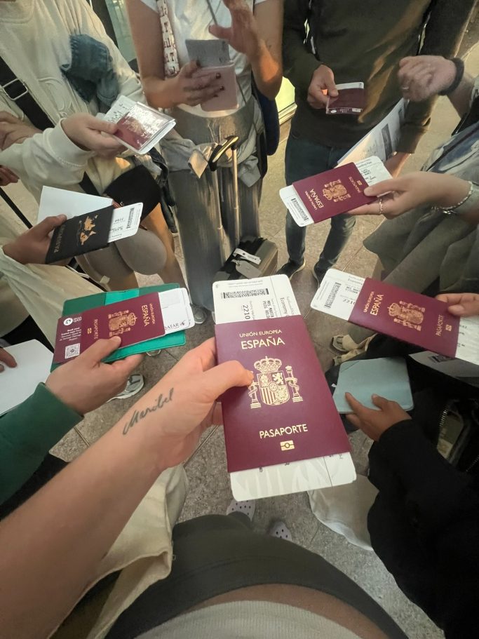 Grupo de personas sosteniendo pasaportes en un entorno de espera.